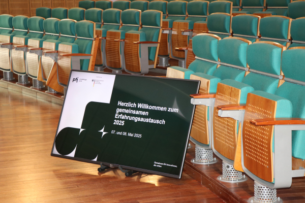 Screen mit Titelfolie vor Zuschauerreihen