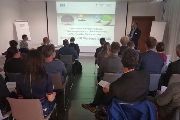 Publikum von hinten mit Blick auf Präsentation